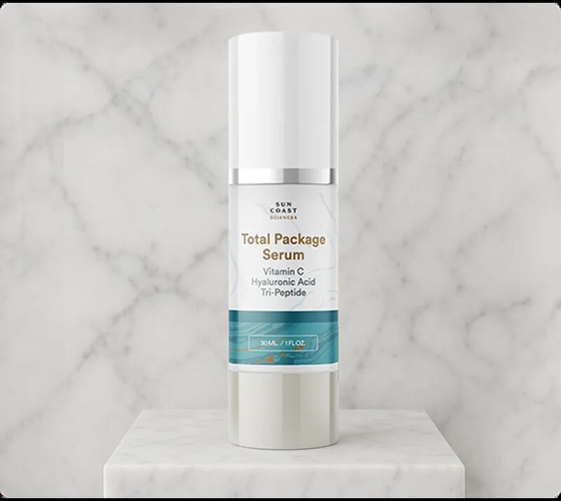 White bottle of Total Package Serum on a marble surface.